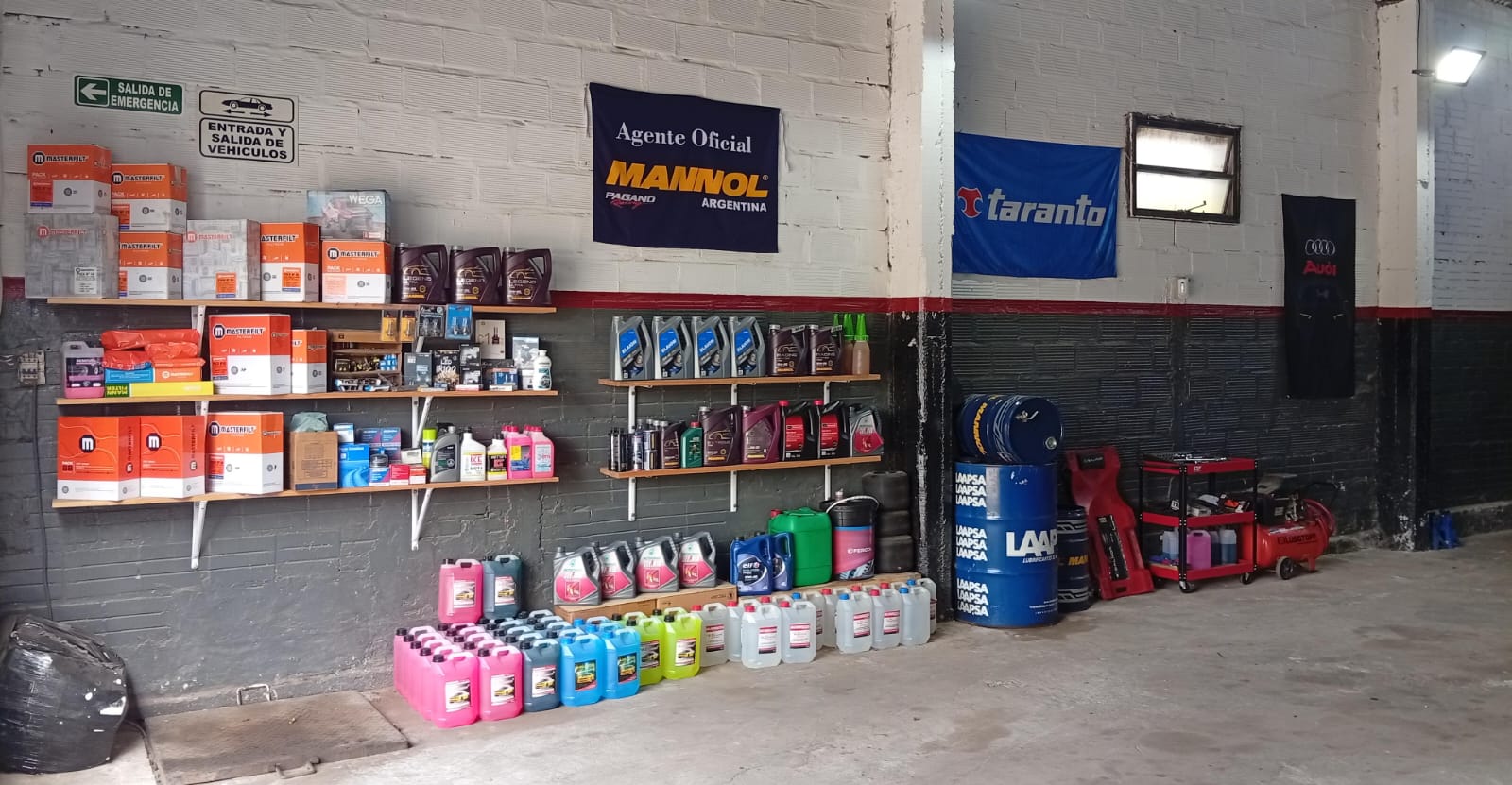 Interior de Pagano Racing con estanterías de aceites, filtros y productos para el mantenimiento del auto